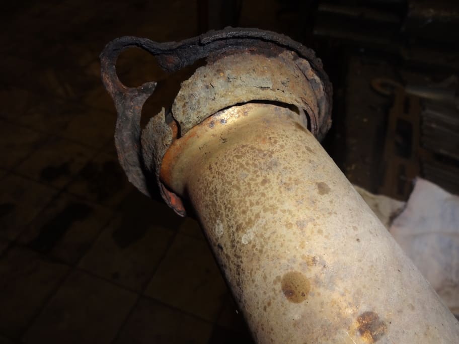 Сгнивший деформированный фланец глушителя крупным планом